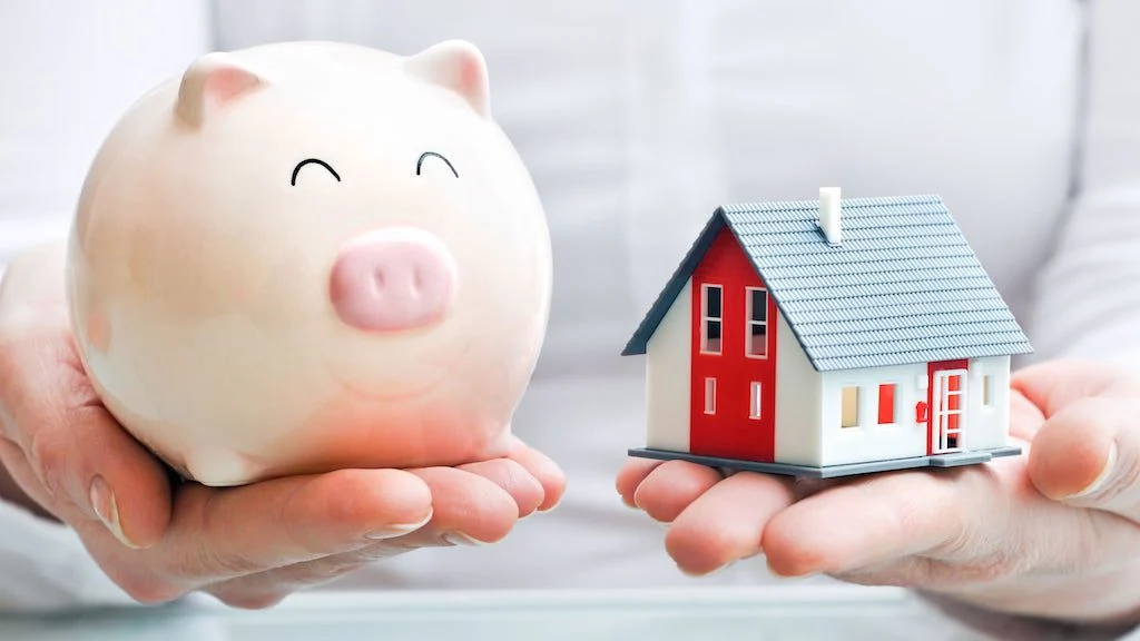 pink piggy bank next to model home