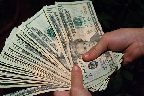hands holding a fanned stack of 20 dollar bills