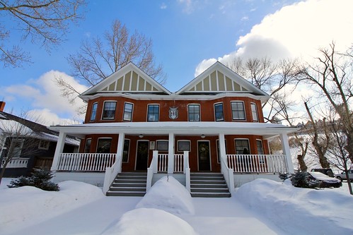 duplex colonial home with snow on the sidewalk
