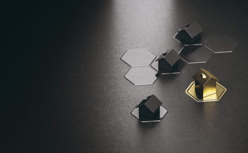 Three black blocks and one gold one all shaped like houses