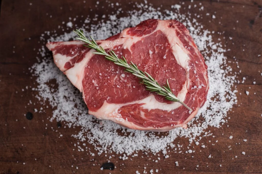 Raw Steak on Brown Wooden Table