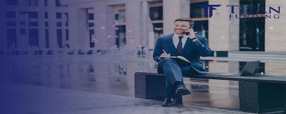 man sitting on a bench outside of a building while talking on his cell phone