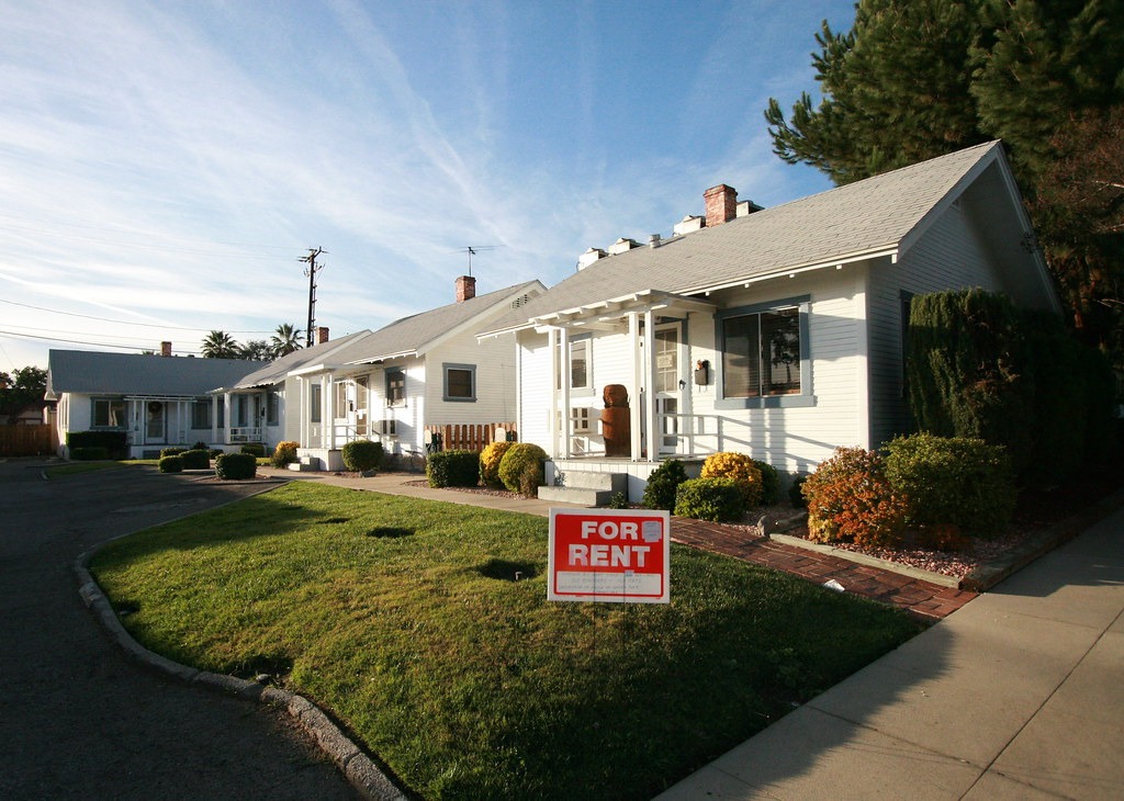 Rental properties with a for rent sign in the front yard